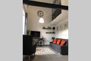 sala de estar con sofá y mesa en Appartement Loft dans domaine historique d'exception en Vernaison