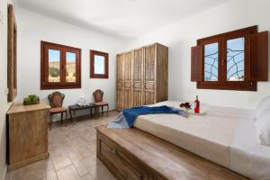 a bedroom with a large bed and two chairs at Villa Anastasia in Líndos