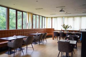 a dining room with tables and chairs and windows at Hotel Prins van Oranje in Diest
