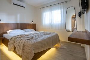 カラミツィにあるAmmos Kalamitsiのベッドルーム(ベッド1台、大きな鏡付)