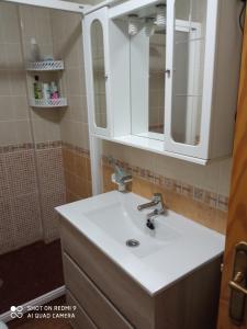 een badkamer met een witte wastafel en een spiegel bij Casa Angelus in Águilas