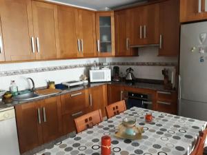 a kitchen with a table and a white refrigerator at Casa Angelus in Águilas +14 photos
