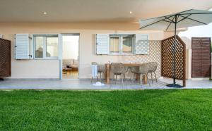 a patio with a table and chairs and an umbrella at Ammos Kalamitsi in Kalamitsi