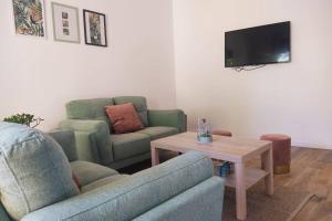 a living room with a couch and a table and a tv at Villa canne à sucre in Saint-Louis