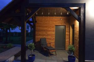 une pergola en bois avec une chaise sur une terrasse dans l'établissement Ferienhaus an der Plantage, à Dresde