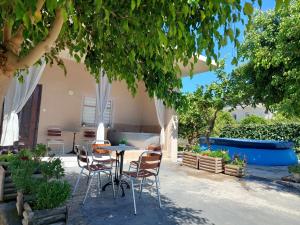 a patio with a table and chairs under a tree at Mommy's House in Angeliana