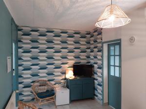 Zimmer mit einer blau-weißen karierten Wand in der Unterkunft Gîte de la Plage in Lézardrieux