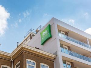 a green building with a sign on the front of it at ibis Styles Den Haag Scheveningen in Scheveningen