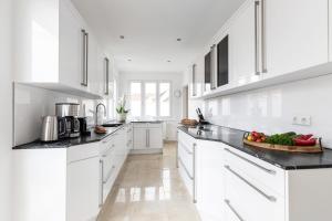 a white kitchen with a bowl of vegetables on the counter at PRIMERA Villa in Singen