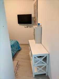 een kamer met een tv en een tafel met een tv-stand bij Casa Giada in SantʼAntìoco