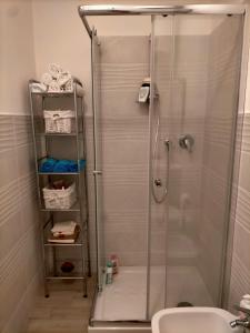 een douche met een glazen deur in de badkamer bij Casa Giada in SantʼAntìoco