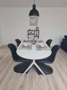Rent & Relax في مول: طاولة بيضاء مع كراسي سوداء في الغرفة