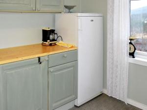 eine Küche mit einem weißen Kühlschrank neben einem Fenster in der Unterkunft Holiday home vassenden in Vassenden