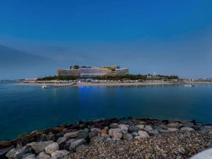 a view of a resort from the shore of a body of water at Rixos The Palm Luxury Suite Collection - Ultra All Inclusive in Dubai