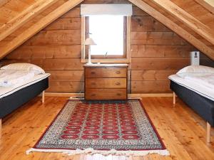a bedroom with two beds and a dresser in a attic at Secluded Mountain Retreat-By Traum in Vassenden