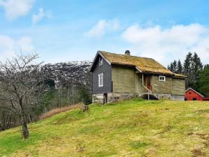 una vecchia casa in cima a una collina erbosa di Holiday home vassenden a Vassenden