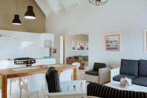 a kitchen and living room with a table and chairs at Pebbles in Paternoster
