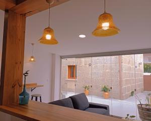 a living room with two pendant lights and a table at Albergue Hostel Nuestra Señora del Camino in Combarro