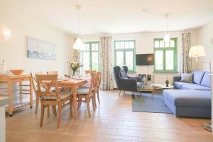 a living room with a table and a blue couch at Ferienhaussiedlung Strandperlen Sanddornhof 3b (Typ VI) in Wustrow