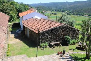 un pequeño edificio de piedra con techo rojo en Lugar da Lourida, en Caminha