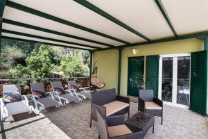 a covered patio with chairs and tables and windows at Vista Del Diamante Apartments in Apolpaina