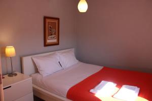 a bedroom with a bed with a red and white blanket at Lugar da Lourida in Caminha +26 photos