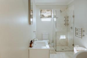 a white bathroom with a shower and a sink at Pebbles in Paternoster +11 photos