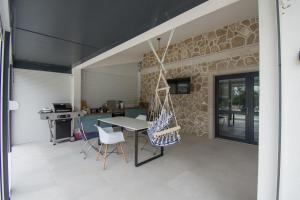 a patio with a table and chairs and a stone wall at Villa Kamena in Vitina