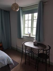 a bedroom with a table and chairs and a window at Jolly Sailor in Cawood