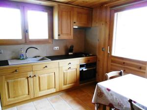 a kitchen with wooden cabinets and a sink and a table at Appartement les 4 Monts in Megève