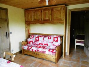 a bed with red and white pillows in a room at Appartement les 4 Monts in Megève