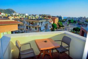 a table and chairs on a balcony with a view of a city at Atak Apart Hotel in Alanya