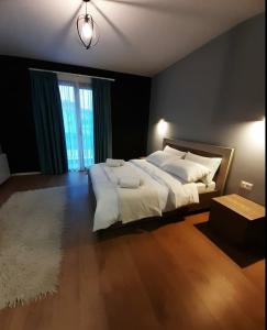 een slaapkamer met een groot bed en een groot raam bij House of Horses Shtepia e Kuajve in Korçë