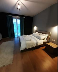 a bedroom with a large bed and a large window at House of Horses Shtepia e Kuajve in Korçë