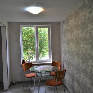 a table and chairs in a room with a window at fantasy park in Ventspils