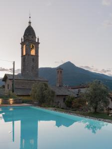 a building with a clock tower next to a swimming pool at Casa Olea Hotel in Cremia