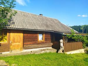 ヴェルホヴィナにあるStarovitska Hata - Ethno-cottageの目の前に像のある木造家屋