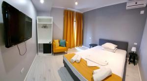 una habitación de hotel con cama y televisor de pantalla plana en CHG Boutique, en Costinesti