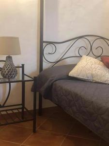 a bedroom with a bed with a lamp and a side table at CASA DO POÇO in Faro