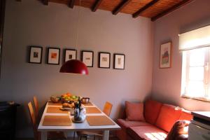 comedor con mesa y sofá rojo en Lugar da Lourida, en Caminha