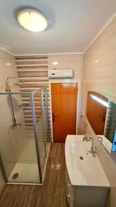 a bathroom with a shower and a sink and a mirror at Apartments Crljen in Brodarica +41 photos