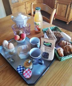 un tavolo con un vassoio di prodotti per la colazione di Chambres en chalet petit déjeuner inclus a La Côte dʼArbroz