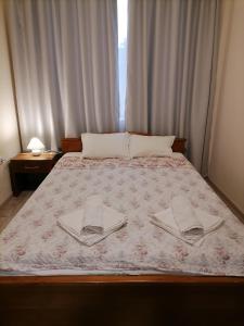 a bedroom with a bed with two towels on it at White home-apartament in Burgas
