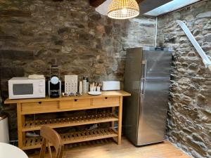 een keuken met een koelkast en een tafel met een magnetron bij Maison del Arc in Jaca