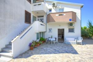 a white house with a staircase and a patio at Apartment Nena in Krk