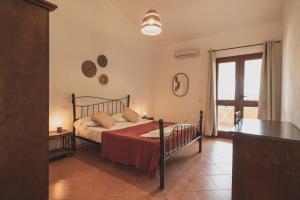 una camera con un letto in una stanza con una finestra di Anima Hotel Sardinia a Fluminimaggiore
