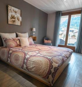 ein Schlafzimmer mit einem Bett und einem großen Fenster in der Unterkunft Chambres en chalet petit déjeuner inclus in La Côte dʼArbroz