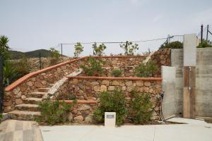 eine steinerne Wand mit einer Treppe mit Pflanzen in der Unterkunft Casa Chersonnesus in Teulada