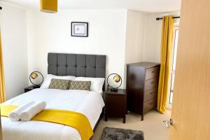 a bedroom with a large bed with a yellow blanket at Smartrips Apartments - Lakeside/Thurrock in West Thurrock