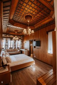 a bedroom with a large bed and a chandelier at KERCULLA Resort in Gjirokastër